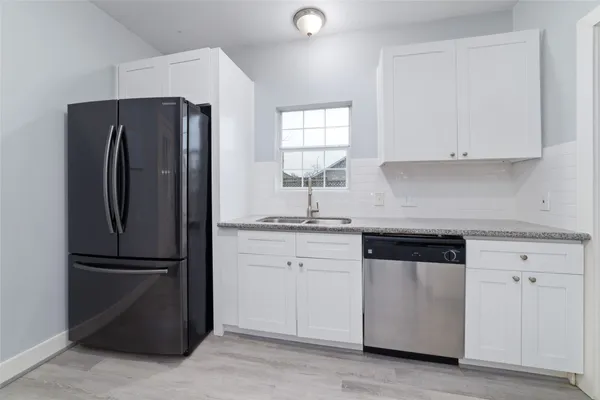 a kitchen with a refrigerator sink and cabinets
