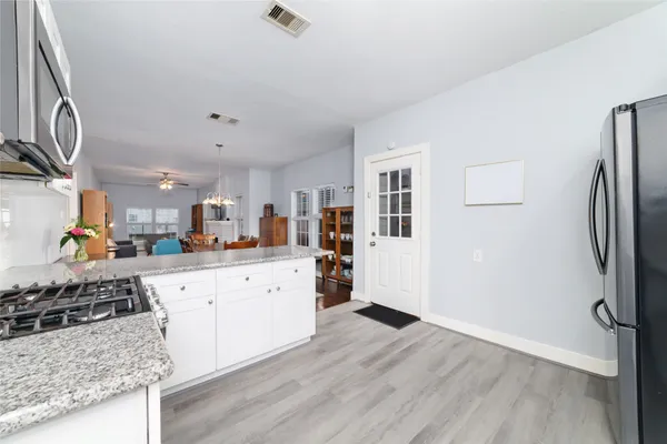 a kitchen with stainless steel appliances granite countertop a refrigerator and a stove top oven