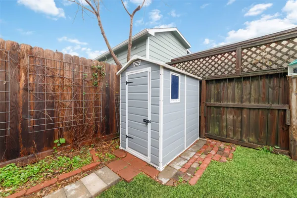 a backyard of a house with potted plants and wooden fence