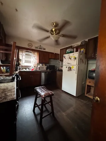 a kitchen with refrigerator and chairs