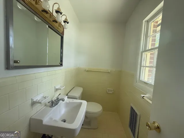 a bathroom with a sink a toilet and mirror