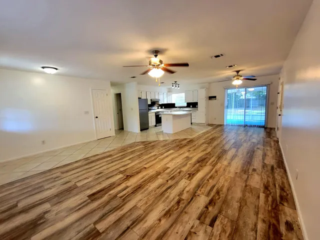 a view of a kitchen with kitchen island wooden floor center island and stainless steel appliances