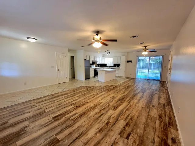a view of a kitchen with kitchen island wooden floor center island and stainless steel appliances