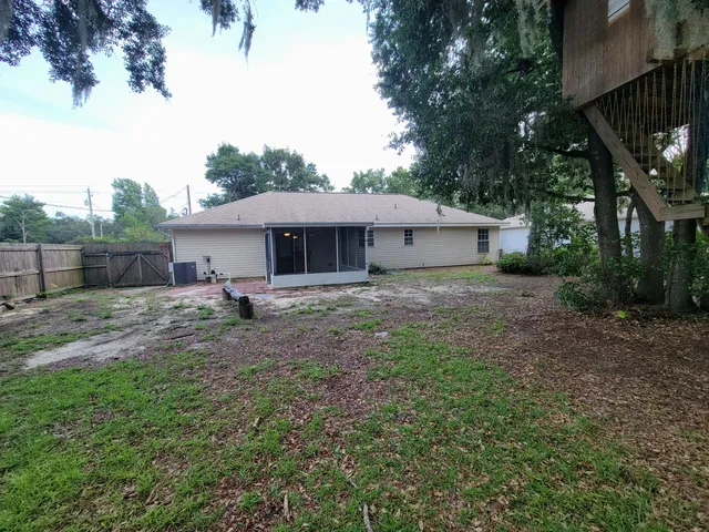 a view of a house with a yard and tree