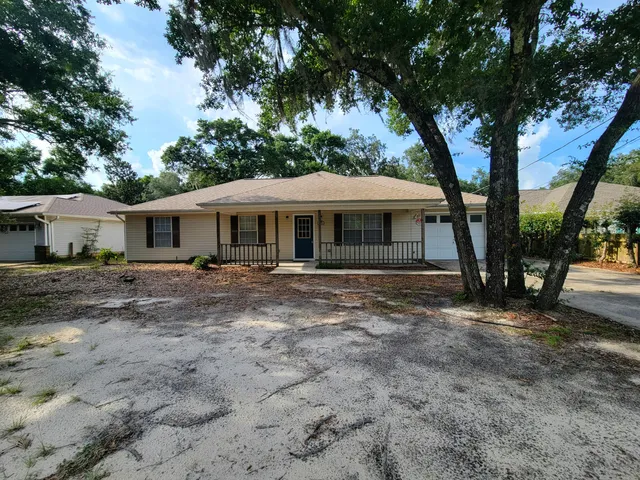 a view of a house with a tree in front of it