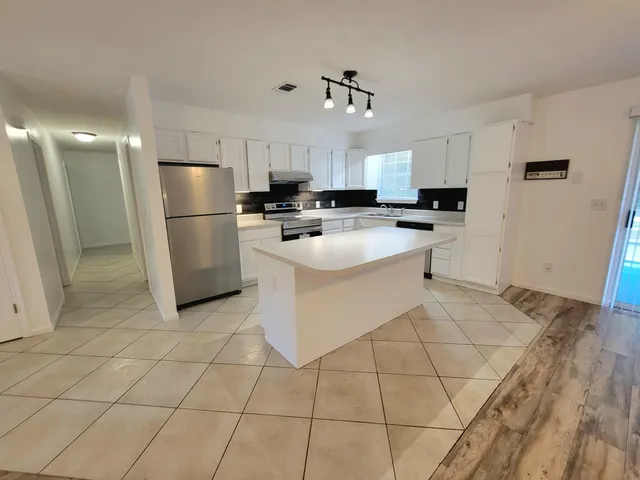 a kitchen with stainless steel appliances a refrigerator sink and microwave