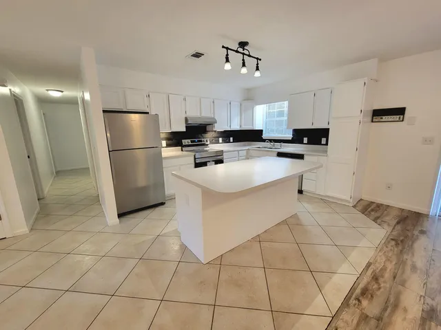 a kitchen with stainless steel appliances a refrigerator sink and microwave