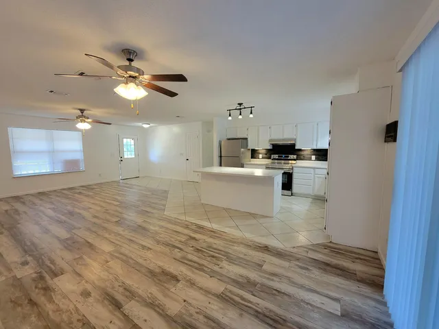 a view of a kitchen with a sink cabinets and wooden floor