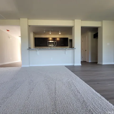 a view of empty room with wooden floor and windows