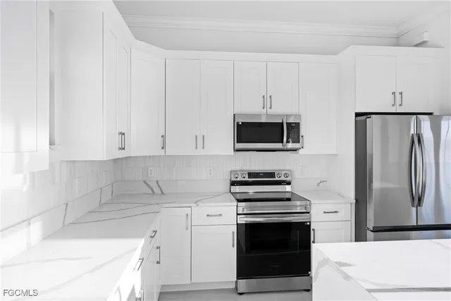 a kitchen with white cabinets and stainless steel appliances