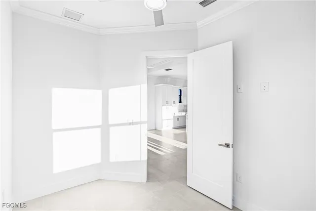 a room with a white bed and a refrigerator