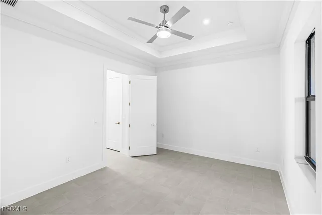 an empty room with a ceiling fan and a window