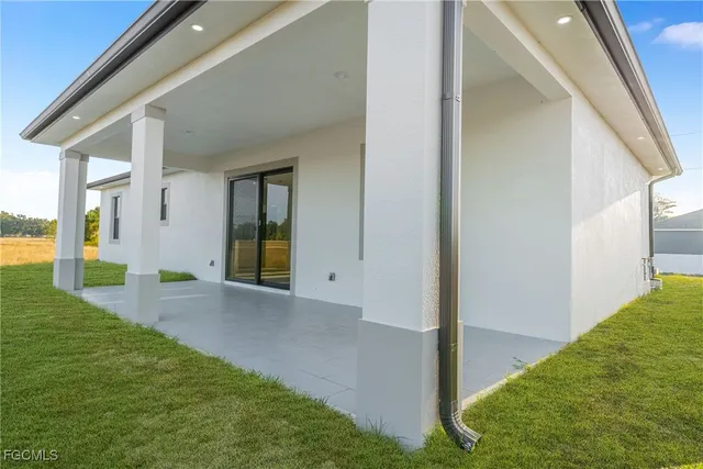 a white house with a big yard and large trees with a big yard