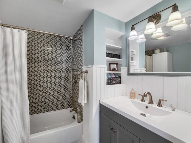 a bathroom with a bathtub a sink and mirror