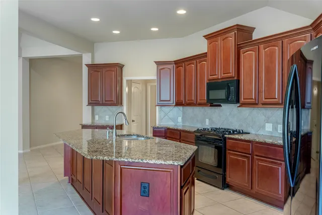 a kitchen with kitchen island granite countertop a sink and cabinets