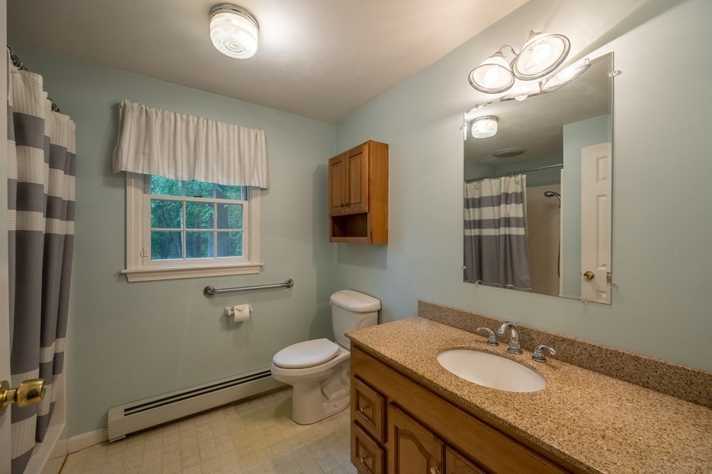 658 Middle Road Acushnet, MA 02743 - Photo 27 of 32 a bathroom with a granite countertop toilet sink and mirror
