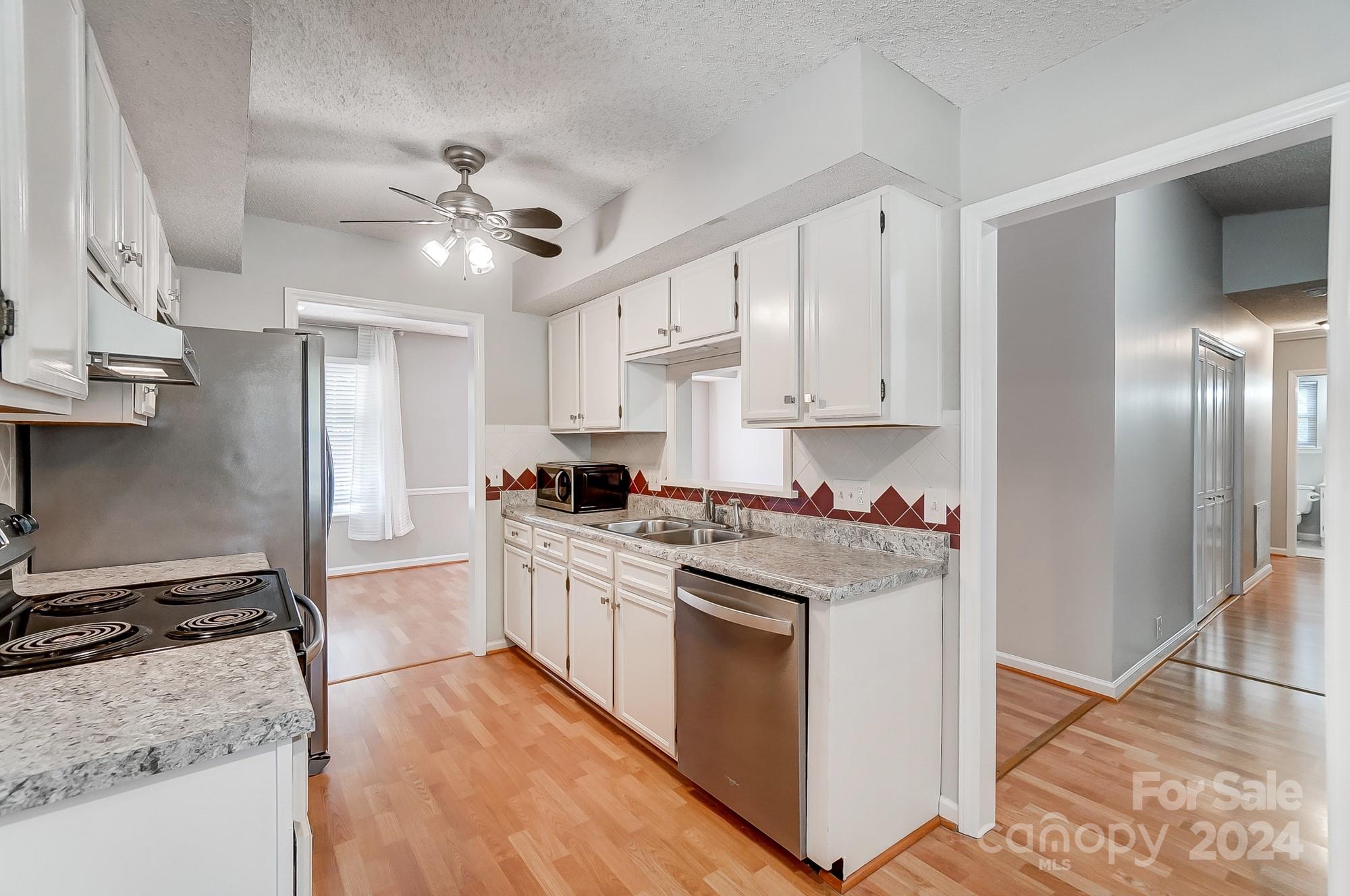 6510 Patchwork Circle Charlotte, NC 28270 - Photo 14 of 48 a kitchen with stainless steel appliances granite countertop a stove top oven a refrigerator a sink and white cabinets