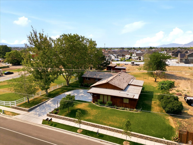 2252 West 800 North Clinton, UT 84015 - Photo 34 of 38 Expansive property featuring a residence with a shingle roof, a large paved driveway, white picket fencing, and mature trees