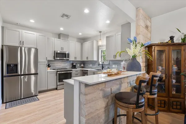 a kitchen with kitchen island granite countertop a sink stove and refrigerator