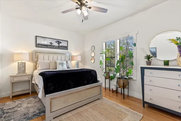 a bedroom with a bed lamp and a potted plant