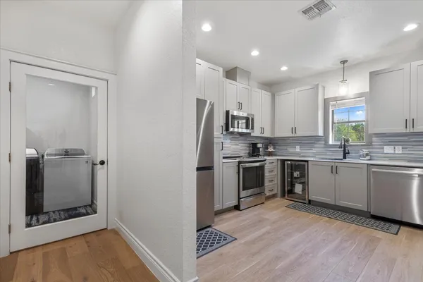 a kitchen with a refrigerator and white cabinets