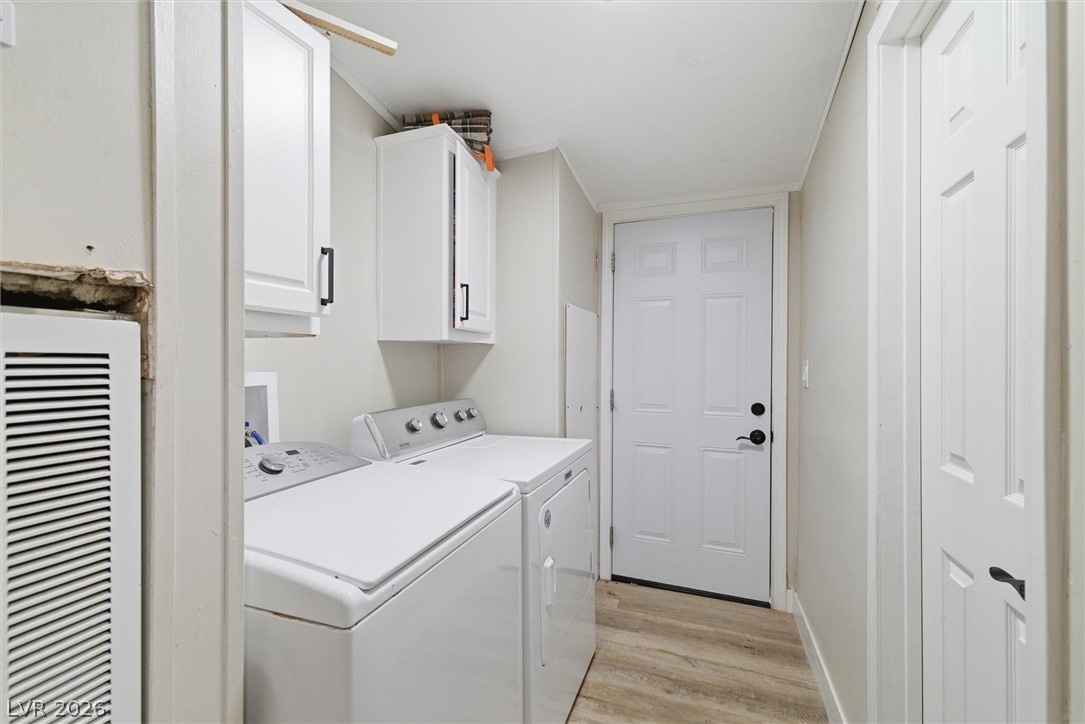 4331 Retread Road Pahrump, NV 89048 - Photo 21 of 31 A well-appointed utility room features a washer and dryer with convenient upper cabinetry and durable wood-look flooring.