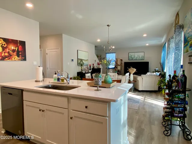 a view of a kitchen with kitchen island stainless steel appliances a sink and living room view