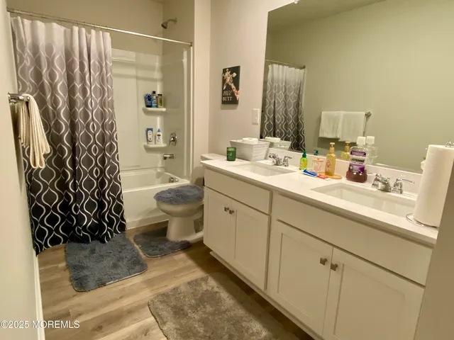a bathroom with a double vanity sink toilet and shower
