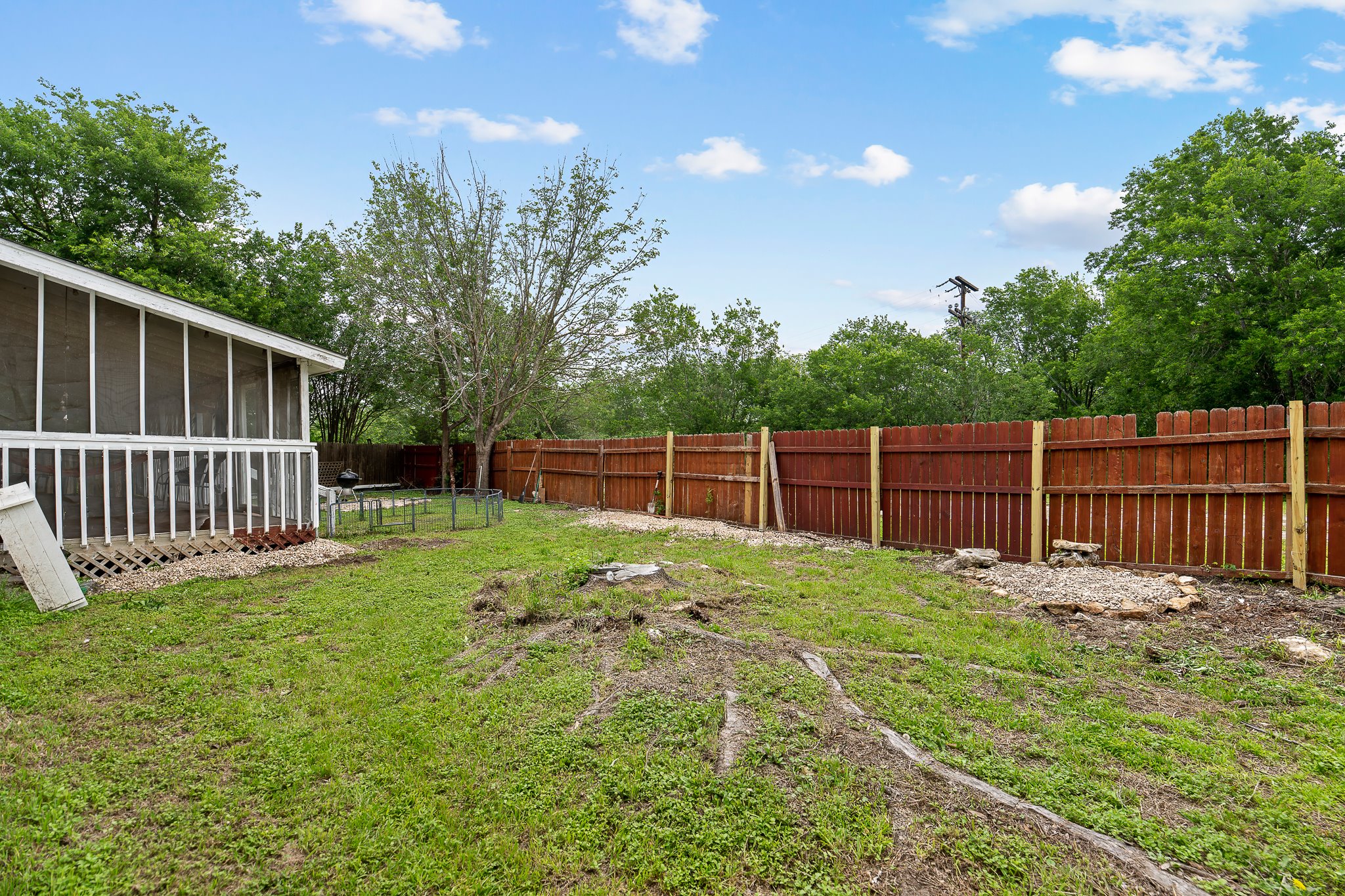 11737 Rydalwater Lane Austin, TX 78754 - Photo 38 of 40 Expansive backyard featuring a screened porch, white railing, and a wooden privacy fence