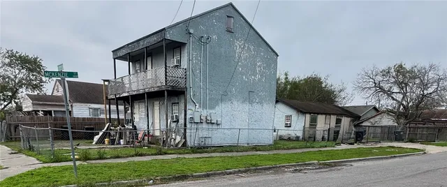 a view of a house with brick walls and a yard with plants