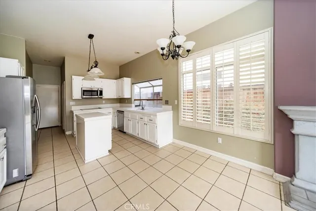 a kitchen with stainless steel appliances kitchen island granite countertop a stove a sink and a refrigerator