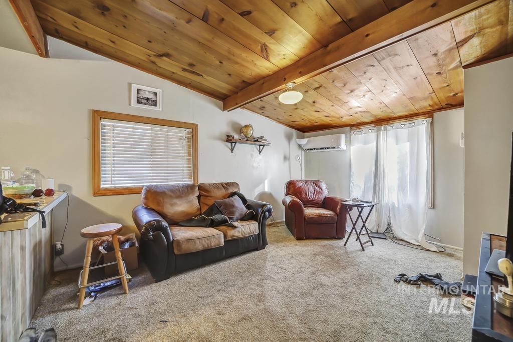 111 2nd Street Rupert, ID 83350 - Photo 31 of 45 Vaulted wood-finish ceilings featuring exposed beams, light gray walls, a window with wood trim and horizontal blinds, and a built-in wall unit