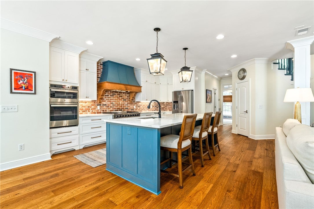 1657 Abby Road Auburn, AL 36830 - Photo 6 of 39 This bright kitchen features an expansive island and rich wood flooring, perfect for gatherings.