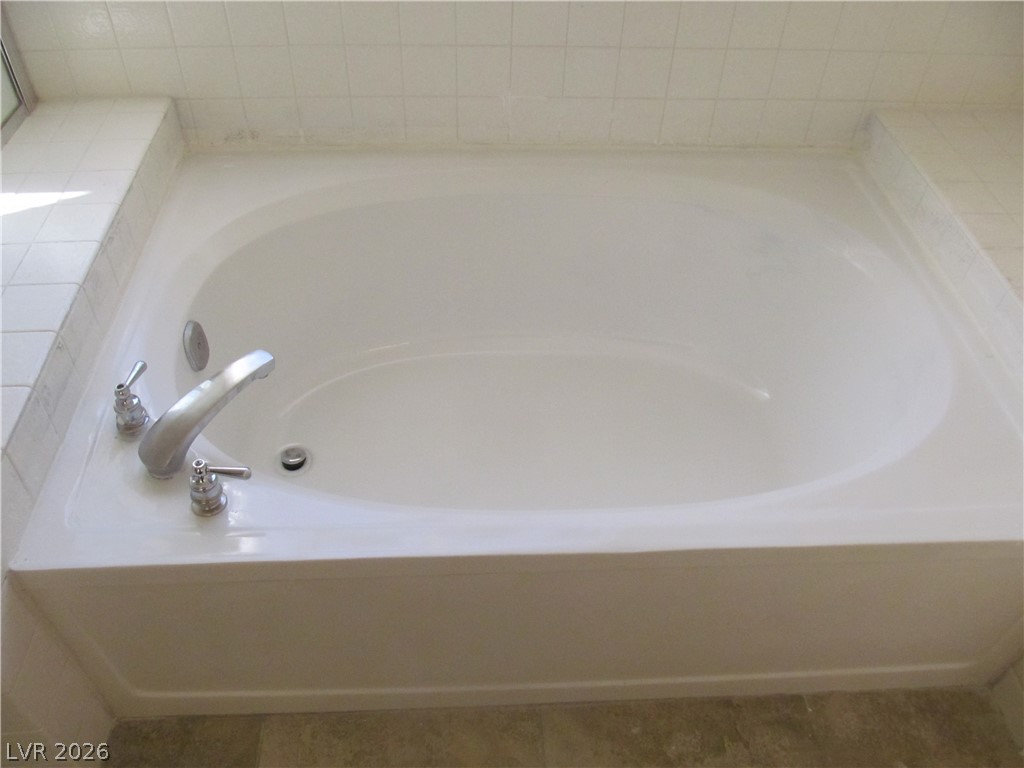 8701 Crescent Ridge Lane Las Vegas, NV 89134 - Photo 21 of 28 Relax in the deep, built-in soaking tub, perfect for unwinding after a long day.