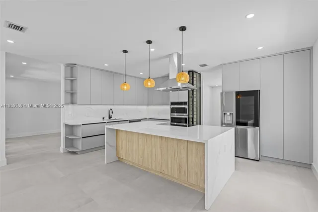 a large kitchen with stainless steel appliances kitchen island a large counter top and a sink