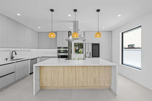 a large kitchen with stainless steel appliances kitchen island granite countertop a sink a stove and a refrigerator