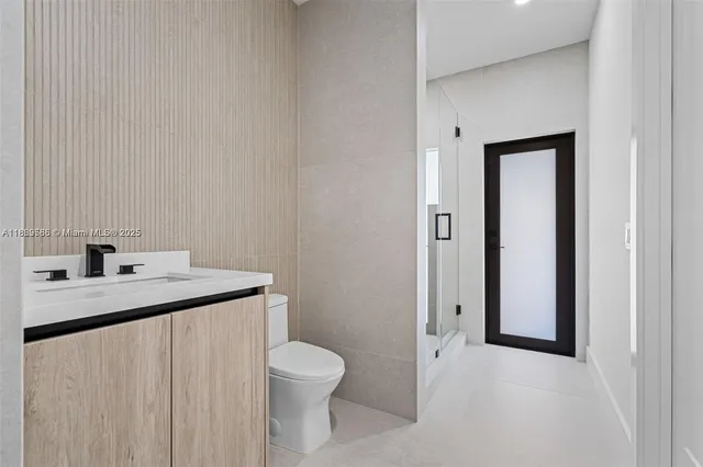 a bathroom with a toilet sink vanity and mirror