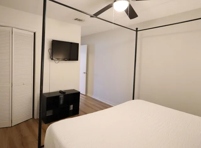 a bedroom with a bed and a flat screen tv