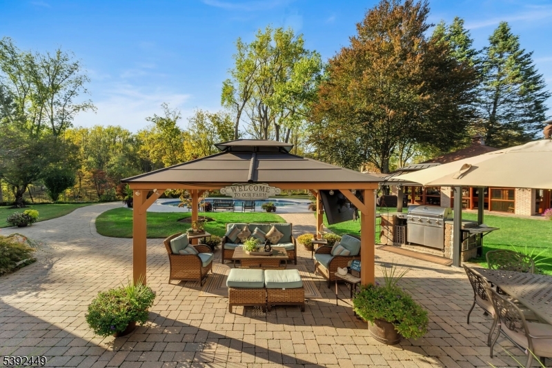 37 Pequest Road Andover, NJ 07821 - Photo 12 of 50 a view of a patio with table and chairs under an umbrella