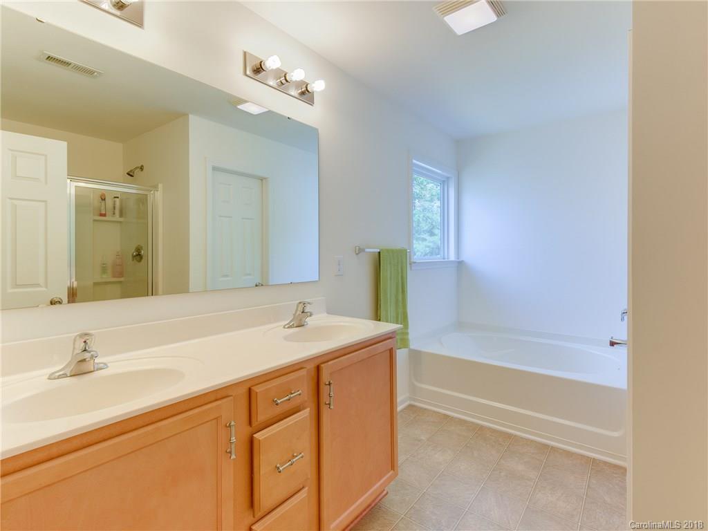 9502 Fernspray Road Charlotte, NC 28215 - Photo 13 of 20 a bathroom with a sink double vanity granite tub shower and a mirror