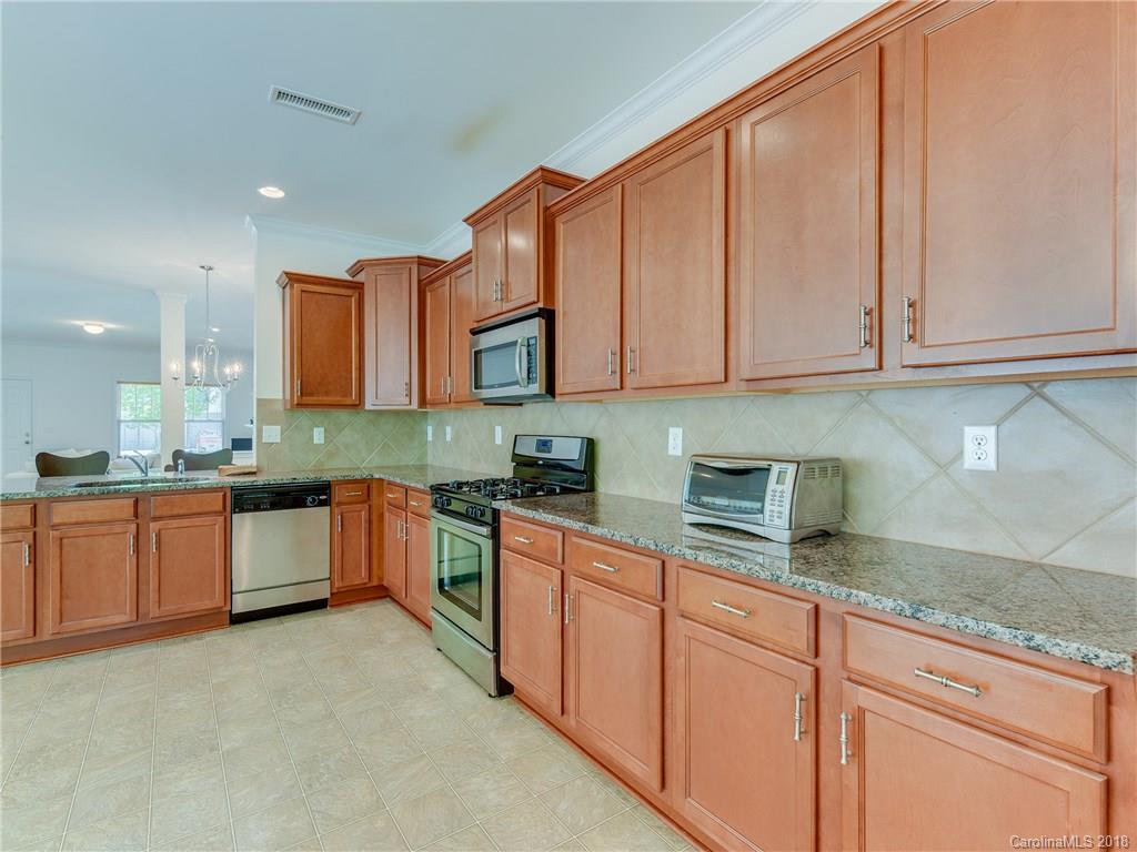 9502 Fernspray Road Charlotte, NC 28215 - Photo 5 of 20 a large kitchen with stainless steel appliances granite countertop a stove a sink and a granite counter tops