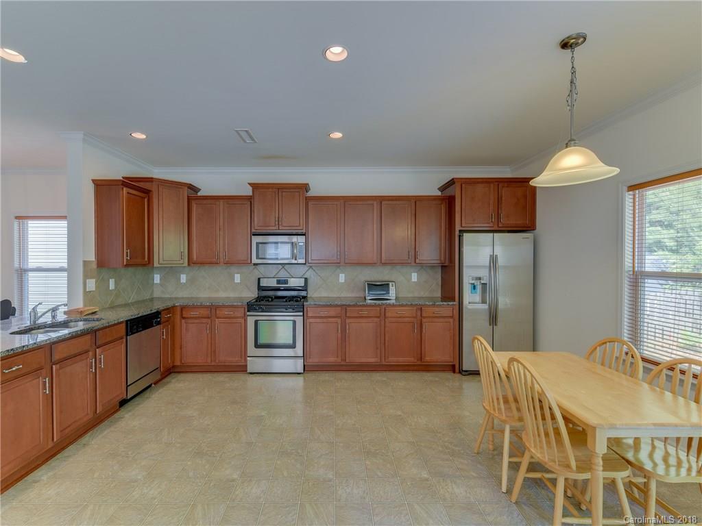 9502 Fernspray Road Charlotte, NC 28215 - Photo 6 of 20 a kitchen with stainless steel appliances granite countertop a sink refrigerator and cabinets