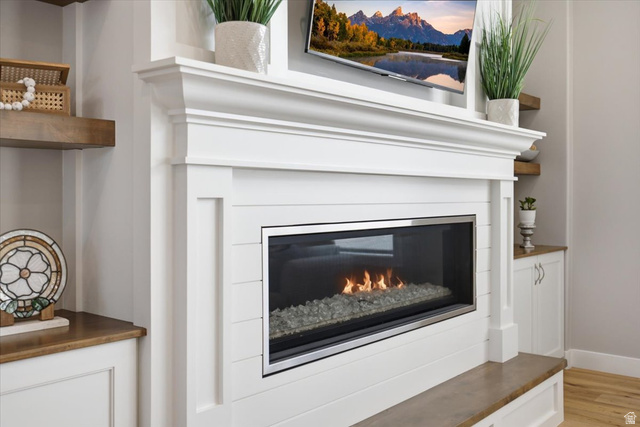 21 Pier Place Tooele, UT 84074 - Photo 11 of 112 Fireplace surround featuring a gas insert with glass media, a substantial mantel, and white shiplap detailing