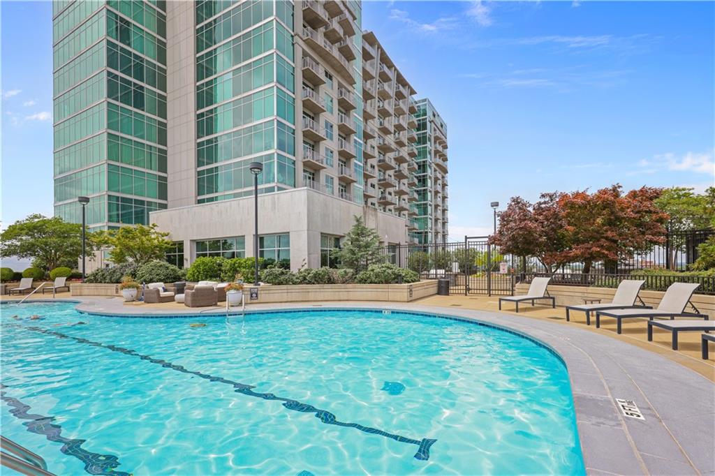 250 Pharr Road Northeast, Unit 606 Atlanta, GA 30305 - Photo 26 of 31 a view of a swimming pool with a lawn chairs and plants