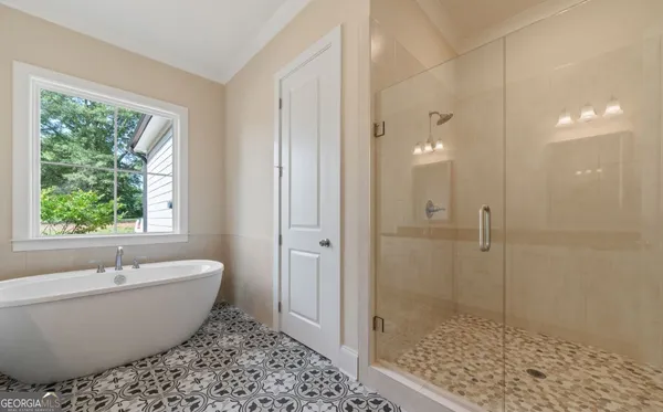 a bathroom with a granite countertop double vanity sink a mirror and a bathtub