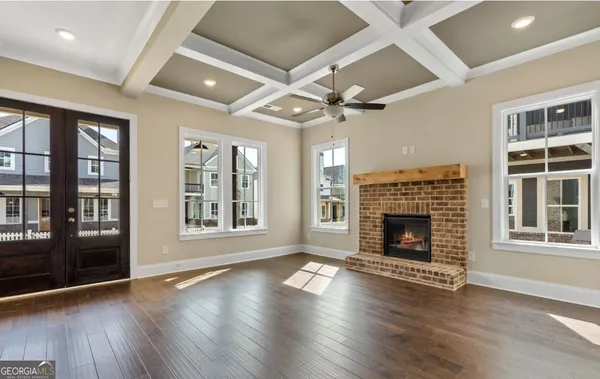 a open kitchen with granite countertop a stove top oven a sink dishwasher a dining table and chairs with wooden floor