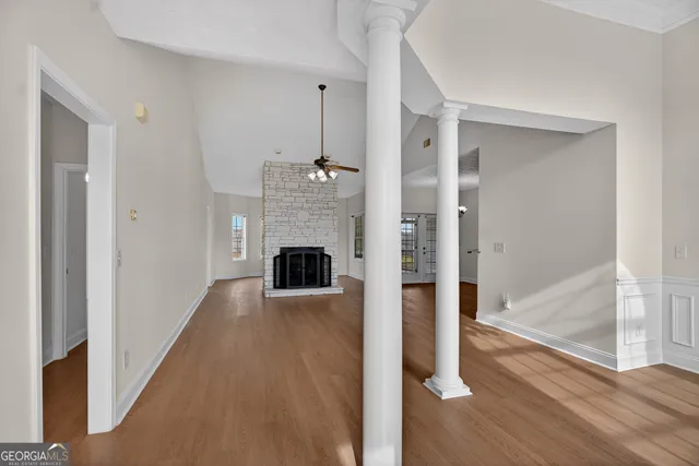 a view of a hallway with wooden floor and staircase