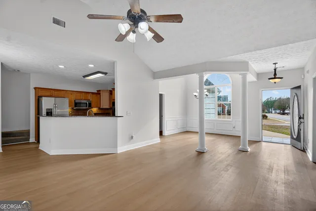 a view of a livingroom with wooden floor and a ceiling fan