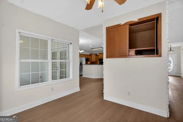an empty room with wooden floor and cabinet