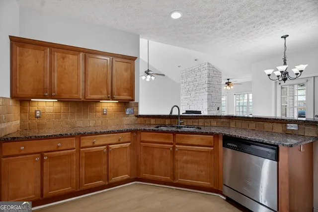 a kitchen with granite countertop a sink stainless steel appliances and cabinets